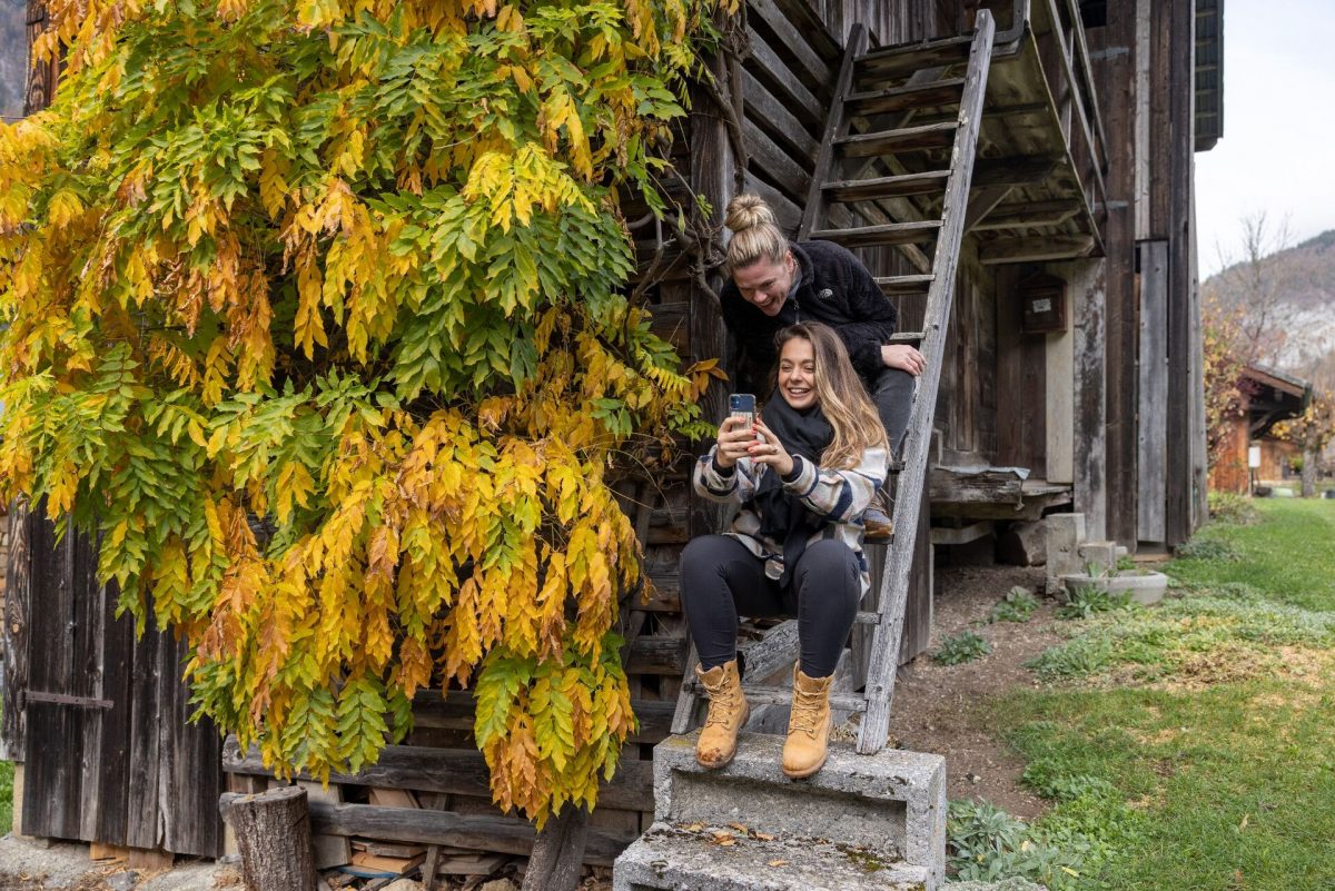 Couple faisant une pause devant un chalet entouré de feuillage d’automne